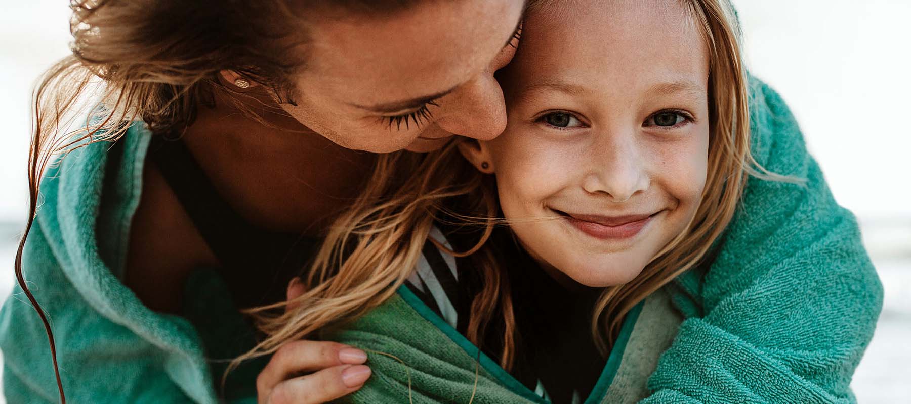 mother and daughter hugging in towels