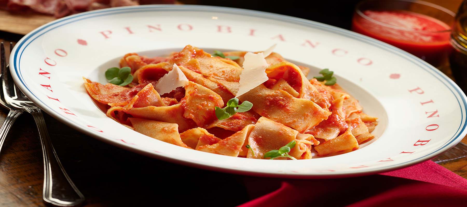 pino bianco pasta with red sauce in a large white bowl